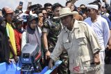 Menteri Pertahanan Prabowo Subianto meninjau perahu saat pembagian perahu nelayan dan bersih-bersih pantai Pangandaran di Pelabuhan Cikidang, Kabupaten Pangandaran, Jawa Barat, Rabu (11/10/2023). Dalam kunjungannya Prabowo Subianto memberikan bantuan 10 perahu untuk nelayan dan mengajak kepada masyarakat untuk menjaga kebersihan lingkungan laut. ANTARA FOTO/Adeng Bustomi/agr