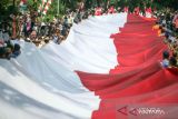 Personel gabungan TNI-Polri membawa bendera Merah Putih berukuran 5x100 meter saat Kirab Bendera Merah Putih di Cibinong, Kabupaten Bogor, Jawa Barat, Kamis (12/10/2023). Kirab Merah Putih tersebut merupakan salah satu rangkaian acara Maulid Akbar Nabi Besar Muhammad SAW dan Tausiah Kebangsaan 1445 H/2023 M di Bogor. ANom.TARA FOTO/Yulius Satria Wijaya/tom/zk