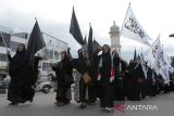 Masyarakat yang tergabung dalam Forum Ukhuwah Muslimin dan Muslimah peduli Palestina  membawa spanduk melakukan longmarch  saat aksi damai di kawasan Masjid Raya Baiturrahman, Banda Aceh, Aceh, Jumat (13/10/2023). Forum Ukhuwah Muslimn dan Muslimat  mengutuk serangan zionis Israel terhadap Palestina dan mendesak  negara negara Arab dan PBB  berperan dalam mewujudkan situasi kondusif di Palestina. ANTARA FOTO/Ampelsa.