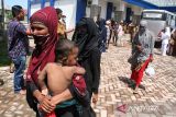 Pengungsi etnis Rohingya berjalan menuju tempat penampungan sementara di Gedung SKB Bireuen, Aceh, Senin (16/10/23). Sebanyak 36 orang pengungsi etnis Rohingya, terdiri dari 14 orang laki-laki, 12 orang perempuan dan 10 orang anak-anak ditemukan terdampar di perairan laut Matang Pasi, Kecamatan Peudada Kabupaten Bireuen, Aceh. ANTARA/Rahmad