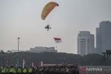 Personel polisi menggunakan paramotor mengibarkan bendera Merah Putih dalam apel Gelar Pasukan Ops Mantap Brata 2023-2024 di Lapangan Silang Monas, Jakarta, Selasa (17/10/2023). Apel yang diikuti 2.926 personel dari unsur Polri, TNI, dan jajaran unsur terkait itu dalam rangka pengamanan Pemilu serentak 2024 di seluruh wilayah Indonesia. ANTARA FOTO/Aprillio Akbar/wsj.