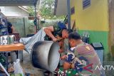 Prajurit TNI Kodim 0413/Bangka membersihkan peralatan masak di SD Negeri 45 Pangkalpinang, Jumat (20/10). (Antara/ Rustam)