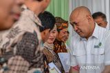 Menteri Koperasi dan UKM Teten Masduki berbincang dengan pelaku usaha saat memberikan sertifikat SNI di Gedung Pusat Layanan Usaha Terpadu (PLUT) di Soreang, Kabupaten Bandung, Jawa Barat, Senin (23/10/2023). Dalam kunjungan kerjanya di Bandung, Teten Masduki berkesempatan untuk memberikan sertifikat SNI kepada pelaku usaha mikro serta meresmikan Gedung PLUT Kabupaten Bandung. ANTARA FOTO/Raisan Al Farisi/agr