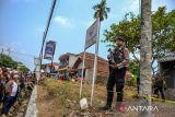 Petugas Kepolisian berjaga saat olah tkp pembunuhan anak dan ibu di Jalan Cagak, Kabupaten Subang, Jawa Barat, Selasa (24/10/2023). Kasus pembunuhan yang terjadi pada 2021 lalu itu baru terungkap dengan pelaku lima tersangka. ANTARA FOTO/Raisan Al Farisi/agr