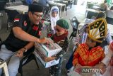 Pelajar Taman Kanak (TK) Nurul Iman melakukan pengalangan donasi di sebuah warkop dalam aksi 