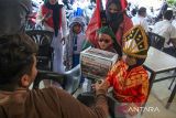 Pelajar Taman Kanak (TK) Nurul Iman melakukan pengalangan donasi di sebuah warkop dalam aksi 