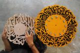 Kerajinan jam dinding kaligrafi. Pekerja menyelesaikan kerajinan jam dinding kaligrafi di Kemayoran, Senenan, Bangkalan, Jawa Timur, Selasa (31/10/2023). Kerajinan jam dinding kaligrafi berbahan kayu jati belanda yang dibuat sesuai pesanan tersebut dibanderol dengan harga mulai Rp50.000 hingga Rp600.000 tergantung tingkat kerumitan pembuatannya. Antara Jatim/Moch Asim/zk.