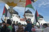 Tiga warga mengibarkan bendera Palestina sebelum menggelar doa bersama  di Masjid Raya Baiturrahman, Banda Aceh, Kamis (2/11/2023). Doa bersama dan penggalangan dana tersebut sebagai wujud  kepedulian dan menyerukan kepada PBB serta negara negara  lainnya  berperan aktif untuk  mengakhir peperangan dan terciptanya  perdamaian di Palestina. ANTARA FOTO/Ampelsa.