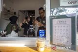 Pembeli memesan kopi menggunakan bahasa isyarat di kedai kopi Sahabat Istimewa di Indramayu, Jawa Barat, Rabu (1/11/2023). Kedai kopi Teman Istimewa binaan PT Kilang Pertamina Internasional (KPI) Balongan tersebut sebagai ruang inkulsi bagi para disabilitas untuk mengembangkan kepercayaan diri dan keahlian dalam berwirausaha. ANTARA FOTO/Dedhez Anggara/agr