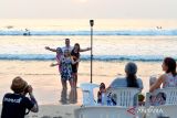 Wisatawan mancanegara (wisman) berfoto saat mengunjungi Pantai Kuta, Badung, Bali, Senin (6/11/2023). Badan Pusat Statistik mencatat jumlah kunjungan wisman ke Indonesia pada periode Januari-September 2023 mencapai 8.513.505 kunjungan atau telah melewati target 8,5 juta wisman sepanjang tahun 2023 yang ditetapkan pemerintah. ANTARA FOTO/Fikri Yusuf/wsj.