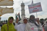 Sejumlah warga dari beberapa organisasi masyarakat membawa poster, spanduk dan bendera palestina saat menggelar aksi di Masjid Raya Baiturrahman, Banda Aceh, Aceh, Rabu (8/11/2023).  Aksi solidaritas yang di serta penggalangan dana itu menyerukan kepada  PBB dan negara lainnya  membebaskan Palestina dari penjajahan Israel . ANTARA FOTO/Ampelsa.