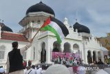 Sejumlah warga dari beberapa organisasi masyarakat membawa poster, spanduk dan bendera palestina saat menggelar aksi di Masjid Raya Baiturrahman, Banda Aceh, Aceh, Rabu (8/11/2023).  Aksi solidaritas yang di serta penggalangan dana itu menyerukan kepada  PBB dan negara lainnya  membebaskan Palestina dari penjajahan Israel . ANTARA FOTO/Ampelsa.
