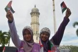 Dua warga  mengibarkan bendera Palestina  saat menggelar aksi di Masjid Raya Baiturrahman, Banda Aceh, Aceh, Rabu (8/11/2023).  Aksi solidaritas yang di sertai penggalangan dana itu menyerukan kepada  PBB dan negara lainnya  membebaskan Palestina dari penjajahan Israel . ANTARA FOTO/Ampelsa.