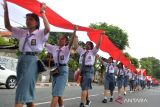 Pelajar membentangkan bendera merah putih saat mengikuti Kirab Merah Putih di Denpasar, Bali, Minggu (12/11/2023). Kirab bendera merah putih sepanjang 1.001 meter yang diikuti ribuan pelajar, personel TNI Polri dan berbagai kelompok masyarakat itu diselenggarakan untuk memperkuat rasa kebangsaan dan nasionalisme pada momentum Hari Pahlawan dan Sumpah Pemuda 2023. ANTARA FOTO/Fikri Yusuf/wsj.