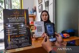 Warga melakukan transaksi menggunakan QRIS di sebuah cafe di Bandung, Jawa Barat, Senin (12/11/2023). UnaFinancial yang merupakan perusahaan penyedia solusi untuk fintech, memprediksi jumlah pengguna aplikasi pembayaran Quick Response (QR) di Indonesia akan tumbuh sebesar 54 persen pada 2025 serta Indonesia akan menjadi negara dengan jumlah pengguna QR terbanyak di Asia Tenggara. ANTARA FOTO/Raisan Al Farisi/agr
