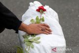 Sejumlah orang meletakan bunga di atas mayat anak-anak yang dikafani secara simbolis dalam sebuah acara yang disebut 'Simfoni Pembunuhan' untuk menggambarkan terhadap serangan Israel di Gaza, di Lapangan Palestina, Teheran, Iran, Senin (13/11/2023). /ANTARA FOTO/REUTERS/Fatemeh Bahrami/Spt.