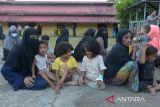 Sejumlah etnis imigran Rohingya berkumpul di lapangan untuk  pendataan saat tiba di penampungan sementara Mina Raya,  di kecamatan Padang Tiji, kabupaten Pidie, Aceh, Selasa (14/11/2023). Sebanyak 196 imigran etnis Rohingya terdiri 61 laki laki, 69 perempuan dewasa, 59 anak anak dan 7 orang imigran melarikan diri yang terdampar di pesisir pantai  daerah itu di pindahkan ke penampungan sementara Mina Raya, kabupaten Pidie. ANTARA FOTO/Ampelsa.