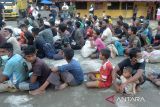 Sejumlah etnis imigran Rohingya berkumpul dilapangan untuk pendataan saat  tiba di penampungan sementara Mina Raya, kecamatan Padang Tiji, kabupaten Pidie, Aceh, Selasa (14/11/2023). Sebanyak 196 imigran etnis Rohingya terdiri 61 laki laki, 69 perempuan dewasa, 59 anak anak dan 7 orang imigran melarikan diri yang terdampar di pesisir pantai  daerah itu di pindahkan ke penampungan sementara Mina Raya, kabupaten Pidie. ANTARA FOTO/Ampelsa.