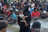 Sejumlah etnis imigran Rohingya berkumpul di lapangan untuk pendataan saat  tiba di penampungan sementara Mina Raya, kecamatan Padang Tiji, kabupaten Pidie, Aceh, Selasa (14/11/2023). Sebanyak 196 imigran etnis Rohingya terdiri 61 laki laki, 69 perempuan dewasa, 59 anak anak dan 7 orang imigran melarikan diri yang terdampar di pesisir pantai  daerah itu di pindahkan ke penampungan sementara Mina Raya, kabupaten Pidie. ANTARA FOTO/Ampelsa.