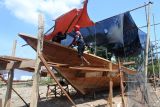 Pekerja membuat perahu tradisional berbahan kayu mahoni di Puger, Jember, Jawa Timur, Rabu (15/11/2023). Perahu nelayan jenis pinisi berukuran 20 meter x empat meter tersebut menghabiskan dana Rp400 juta dengan waktu pembuatan dua bulan. Antara Jatim Jatim/Seno.
