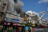 Petugas pemadam kebakaran berusaha memadamkan api yang membakar toko elektronik di Jalan Banceuy, Bandung, Jawa Barat, Selasa (21/11/2023). Petugas pemadam kebakaran menyatakan, kebakaran yang membakar satu unit toko elektronik tersebut diduga karena korsleting listrik. ANTARA FOTO/Raisan Al Farisi/agr
