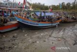 Nelayan berada di atas kapalnya yang bersandar di muara Karangsong, Indramayu, Jawa Barat, Senin (27/11/2023). Menurut nelayan setempat, sejak sebulan terakhir pendangkalan terjadi di muara sungai yang berada di kawasan Pelabuhan Pendaratan Ikan Karangsong tersebut mengakibatkan ratusan kapal kesulitan untuk keluar masuk pelabuhan. ANTARA FOTO/Dedhez Anggara/agr