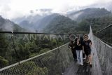 Pengunjung melintas di jembatan gantung Lembah Purba di kawasan wisata Situgunung, Kadudampit, Kabupaten Sukabumi, Jawa Barat, Minggu (26/11/2023). Kementerian Pariwisata dan Ekonomi Kreatif menargetkan kunjungan wisatawan mancanegara naik menjadi 12-14 juta pada 2024 dibandingkan target 2023 sebanyak 8,5 juta kunjungan dan target pergerakan wisatawan nusantara kisaran 1,2 miliar - 1,4 miliar pada 2024. ANTARA FOTO/Henry Purba/agr/nym.