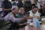 Warga berswafoto dengan Calon Wakil Presiden nomer urut 1 Muhaimin Iskandar (tengah) saat berkampanye di Taman Bungkul, Surabaya, Jawa Timur, Selasa (28/11/2023). Dalam kampanye tersebut Muhaimin Iskandar menyapa warga dan berdialog dengan mayarakat nelayan di Kota Surabaya. Antara Jatim/Moch Asim.