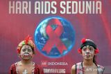 Sejumlah remaja yang berhias pelawak khas Bali berdiri di dekat poster peringatan Hari AIDS Sedunia 2023 di Denpasar, Bali, Jumat (1/12/2023). Kepala Dinas Kesehatan Kota Denpasar dr. Anak Agung Ayu Agung Candrawati menyebut kasus HIV dari tahun ke tahun masih mangalami peningkatan, berdasarkan data sampai September 2023 kasus HIV di Kota Denpasar telah tercatat 15.406 orang, yakni jumlah penularan terbanyak melalui heteroseksual 11.026 orang, homoseksual 3.094 orang, dan penggunaan narkoba suntik 632 orang. ANTARA FOTO/Nyoman Hendra Wibowo/wsj.