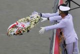 Panglima Komando Armada II Laksamana Muda TNI Yayan Sofiyan (kanan) melempar karangan bunga ke laut saat upacara tabur bunga di atas KRI dr. Soeharso-990 di Koarmada II, Surabaya, Jawa Timur, Jumat (1/12/2023). Kegiatan untuk memperingati Hari Armada itu bertema Armada RI Membangun Kekuatan Laut Nusantara Menuju Indonesia Maju. Antara Jatim/Didik Suhartono.