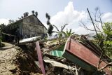 Warga mengamati rumah hancur di Tegalkaso, Desa Bencoy, Cireunghas, Kabupaten Sukabumi, Jawa Barat, Rabu (2/12/2023). Badan Penanggulangan Bencana Daerah (BPBD) Kabupaten Sukabumi mencatat akibat pergeseran tanah sedikitnya lima rumah warga rusak, akses jalan penghubung antar kampung retak dan sebanyak 21 warga terpaksa mengungsi di tempat yang aman. ANTARA FOTO/Henry Purba/agr/nz