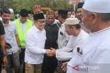 Calon wakil presiden nomor urut 1 Muhaimin Iskandar (kedua kiri) bersalaman dengan warga saat tiba di makam ulama kharismatik Aceh Syeikh Abdurrauf Bin Ali Al-Fansury atau Teungku Syiah Kuala di Banda Aceh, Aceh, Selasa, (5/12/2023). ANTARA/Khalis Surry