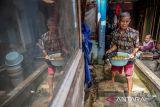Warga membawa ikan untuk di pindang di Sentra Produksi Pindang Ikan di Desa Lengkong, Kecamatan Bojongsoang, Kabupaten Bandung, Jawa Barat, Rabu (6/12/2023). Sentra produksi pindang ikan yang ada sejak 1980 an tersebut mampu memproduksi sebanyak satu kuintal pindang ikan per hari dari setiap rumah serta dipasarkan di berbagai pasar di Kota Bandung. ANTARA FOTO/Raisan Al Farisi/agr
