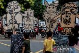 Sejumlah anak didampingi orang tuanya menuliskan pesan antikorupsi saat kegiatan Hari Bebas Kendaraan Bermotor atau Car Free Day (CFD) di Solo, Jawa Tengah, Minggu (10/12/2023). Aksi itu digelar untuk memperingati Hari Antikorupsi Sedunia sekaligus membentuk budaya antikorupsi pada generasi muda Indonesia. ANTARAFOTO/Maulana Surya/rwa.