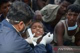 Petugas medis melakukan tes usap (swab test) kepada imigran etnis Rohingyaa setelah mendarat di Desa Blang Raya, Kabupaten Pidie, Aceh, Minggu (10/12/2023).  Sebanyak 180 imigran etnis rohingya terdiri  53 laki-laki, 74 perempuan dan  53 anak anak  yang  mendarat di Pidie  menjalani tes usab untuk mengantisipasi penyebaran COVID-19 dan penyakit menular lainnya.  ANTARA FOTO/Ampelsa