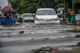 Kendaraan melintasi genangan air di Jalan Soekarno Hatta, Gedebage, Bandung, Jawa Barat, Senin (11/12/2023). Jalan tersebut terendam air setinggi 30 hingga 60 cm serta membuat kemacetan panjang usai hujan deras yang diperparah buruknya drainase di kawasan tersebut. ANTARA FOTO/Raisan Al Farisi/agr
