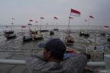 Warga melihat deretan perahu nelayan yang dipasangi bendera Merah Putih di sela acara Sapa Nelayan dalam rangka peringatan Hari Nusantara di Taman Hiburan Pantai Kenjeran, Surabaya, Jawa Timur, Senin (11/12/2023). Kegiatan yang mengusung tema Ikan untuk Generasi Emas 2045 tersebut diharapkan dapat menjadi pelecut semangat dalam memberikan kontribusi terbaik untuk kemajuan sektor kelautan dan perikanan serta pariwisata yang berdampak pada kesejahteraan bagi para nelayan. Antara Jatim/Moch Asim.