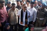 Menteri Perdagangan Zulkifli Hasan membeli barang dagangan pedagang saat kunjungan kerja ke Pasar Batuphat, Muara Satu, Lhokseumawe, Aceh, Jumat (15/12/2023). Kunjungan Menteri Perdagangan tersebut dalam rangka melihat potensi komoditi, Memantau secara langsung harga dan ketersediaan kebutuhan bahan pokok di pasar daerah jelang Natal dan tahun baru 2024. ANTARA/Rahmad