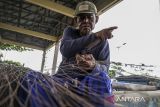 Nelayan memperbaiki jaring ikan di Palabuhanratu, Kabupaten Sukabumi, Jawa Barat, Senin (18/12/2023). Menurut nelayan, untuk perbaikan jaring ikan tersebut dikenakan biaya Rp3.000 hingga Rp5.000 per meter tergantung ukuran dan tingkat kerusakan. ANTARA FOTO/Henry Purba/agr
