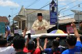 Capres nomor urut 2 Prabowo Subianto membagikan kaos kepada masyarakat usai berziarah ke makam Presiden Soekarno di Blitar, Jawa Timur, MInggu (17/12/2023). Selain berziarah, Prabowo juga melakukan deklarasi dengan gerakan masyarakat perhutanan sosial indonesia di GOR Soekarno-Hatta. Antara Jatim/Irfan Anshori.