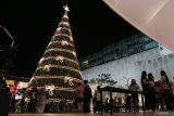 Pengunjung menyaksikan pohon natal setinggi 20 meter di Christmas Wonderland di Pakuwon City Mall, Surabaya, Jawa Timur, Senin (18/12/2023). Christmas Wonderland merupakan acara tahunan yang diselenggarakan dengan menyuguhkan berbagai hiburan seperti wahana, atraksi, sajian kuliner, stan foto serta pohon Natal setinggi 20 meter yang dapat dijadikan tempat rujukan wisata untuk mengisi hari libur Natal 2023 dan Tahun Baru 2024. Antara Jatim/Moch Asim.