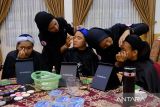 Guru SLB Pontianak Nurmah (kedua kanan) menggunakan bahasa isyarat saat berbicara dengan penyandang disabilitas yang mengikuti pelatihan tata cara make-up profesional di rumah jabatan Wali Kota Pontianak, Kalimantan Barat, Selasa (19/12/2023). Kegiatan yang diselenggarakan oleh TP PKK Kota Pontianak bersama WBM Community tersebut guna meningkatkan rasa percaya diri serta memberikan keterampilan make-up profesional untuk penyandang disabilitas agar dapat berwirausaha. ANTARA FOTO/Jessica Wuysang