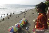 Penjaga pantai mengawasi wisatawan di kawasan Pantai Citepus, Palabuhanratu, Kabupaten Sukabumi, Jawa Barat, Minggu (24/12/2023). Menurut pengelola setempat, jumlah kunjungan wisatawan mengalami peningkatan sebesar 50 persen saat libur Natal dan tahun baru 2024. ANTARA FOTO/Henry Purba/agr