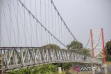 Pekerja menyelesaikan pembangunan jembatan gantung di Jatibarang, Indramayu, Jawa Barat, Rabu (27/12/2023). Kementerian PUPR membangun sebanyak 558 jembatan gantung selama periode 2015-2023 di Indonesia dalam rangka mempermudah konektivitas antardesa. ANTARA FOTO/Dedhez Anggara/agr