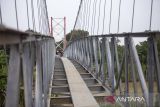 Pekerja menyelesaikan pembangunan jembatan gantung di Jatibarang, Indramayu, Jawa Barat, Rabu (27/12/2023). Kementerian PUPR membangun sebanyak 558 jembatan gantung selama periode 2015-2023 di Indonesia dalam rangka mempermudah konektivitas antardesa. ANTARA FOTO/Dedhez Anggara/agr