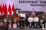 Presiden Joko Widodo mengangkat sertipikat tanah warga saat penyerahan sertipikat tanah untuk rakyat Jawa Timur di Gelora Delta Sidoarjo, Jawa Timur, Rabu (27/12/2023). Presiden menyerahkan sebanyak 4000 sertipikat tanah hasil program Pendaftaran Tanah Sistematis Lengkap (PTSL) di Jatim sebagai upaya memberikan hak hukum bukti kepemilikan tanah kepada masyarakat penerima sertipikat. Antara Jatim/Umarul Faruq.