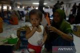 Seorang  imigran etnis Rohingya menyuapakan makanan untuk anaknya di penampungan sementara gedung  Balai Meuseuraya Aceh (BMA), Banda Aceh, Aceh, Minggu (31/12/2023). Kelompok masyarakat di Aceh menyalurkan bantuan kemanusian  berupa makanan yang berasal dari sumbangan warga kepada sebanyak 137 pengungsi imigran etnis Rohingya terdiri dari laki-laki, perempuan dan anak anak yang masih menempati ruangan parkir  gedung BMA. ANTARA FOTO/Ampelsa