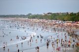 Wisatawan memadati kawasan wisata Pantai Kuta, Badung, Bali, Minggu (31/12/2023). Pantai Kuta dipadati oleh ribuan wisatawan dari berbagai negara untuk berlibur pada akhir tahun 2023. ANTARA FOTO/Fikri Yusuf/wsj.