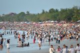 Wisatawan memadati kawasan wisata Pantai Kuta, Badung, Bali, Minggu (31/12/2023). Pantai Kuta dipadati oleh ribuan wisatawan dari berbagai negara untuk berlibur pada akhir tahun 2023. ANTARA FOTO/Fikri Yusuf/wsj.