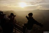 Sejumlah wisatawan mengabadikan gambar matahari terbit di Penanjakan satu Bromo, Pasuruan, Jawa Timur, Senin (1/1/2024). Kawasan Taman Nasional Bromo Tengger Semeru (TNBTS) ramai dikunjungi wisatawan yang sengaja datang untuk menyaksikan matahari terbit pertama ditahun 2024. Antara Jatim/Irfan Sumanjaya.